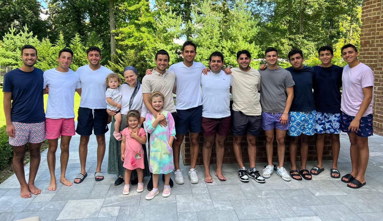 Rabbi and Rebecca Abergel with their children and a dozen young men outside a home in the United States.
